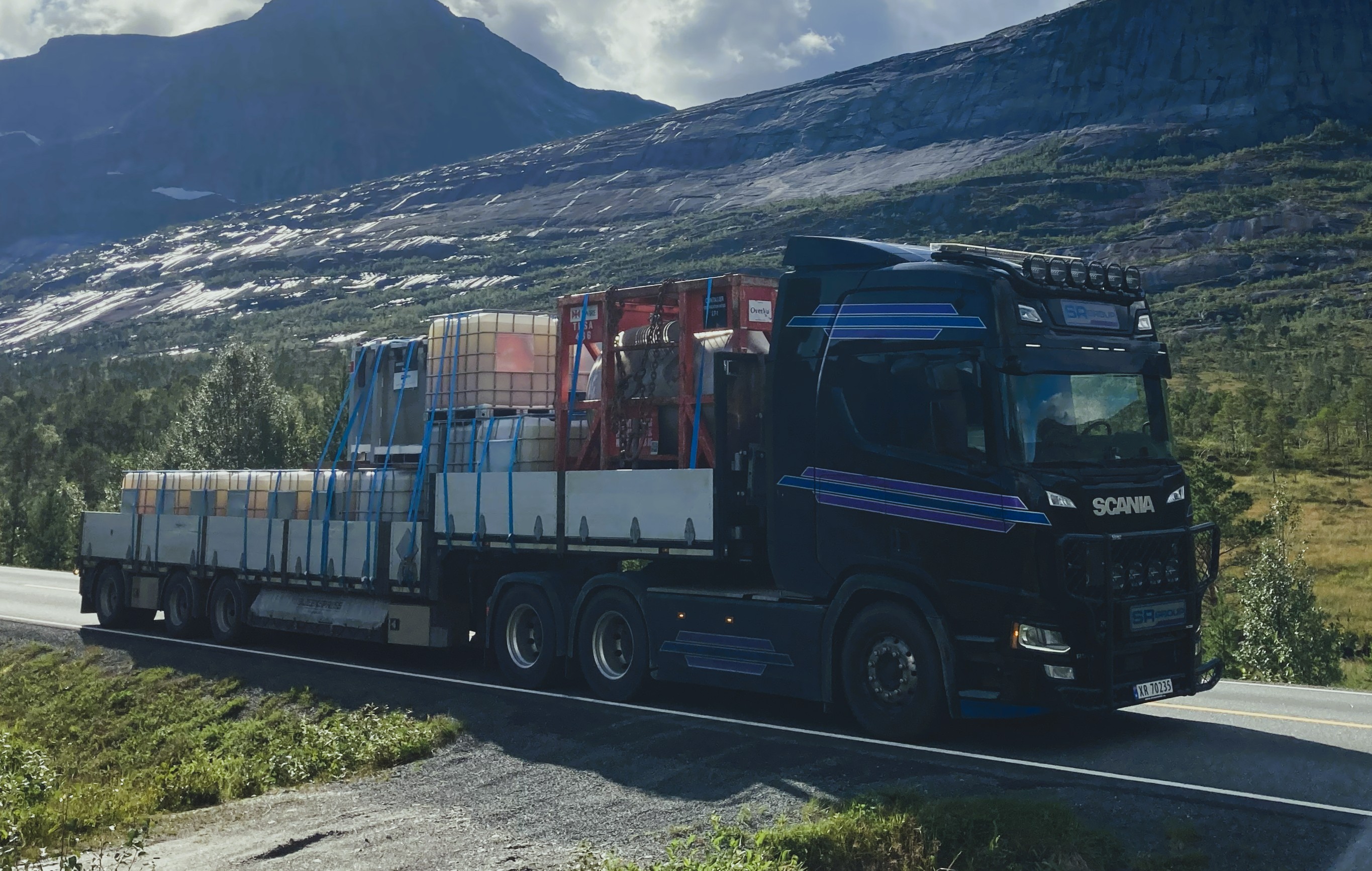 Åpen jumbo med last i fjellandskap